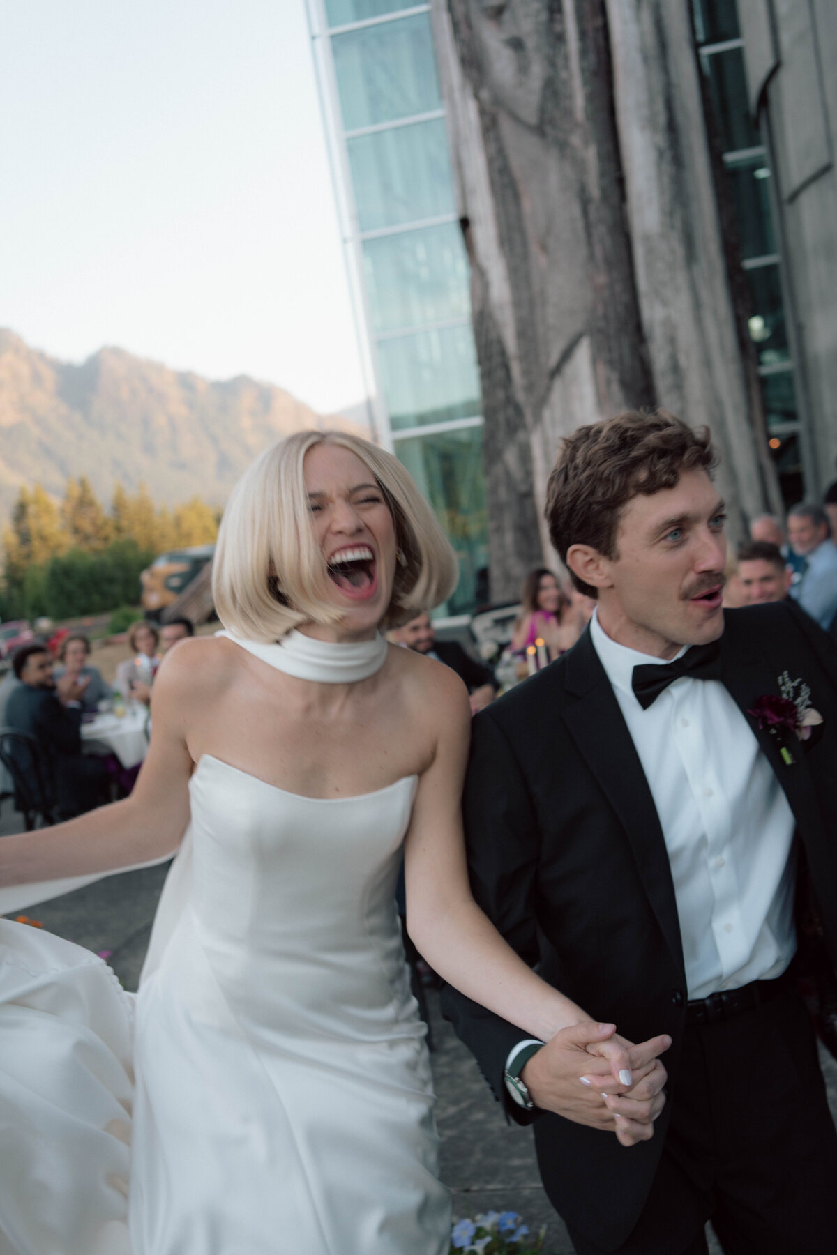 Bride laughing with groom during outdoor wedding celebration in the mountains
