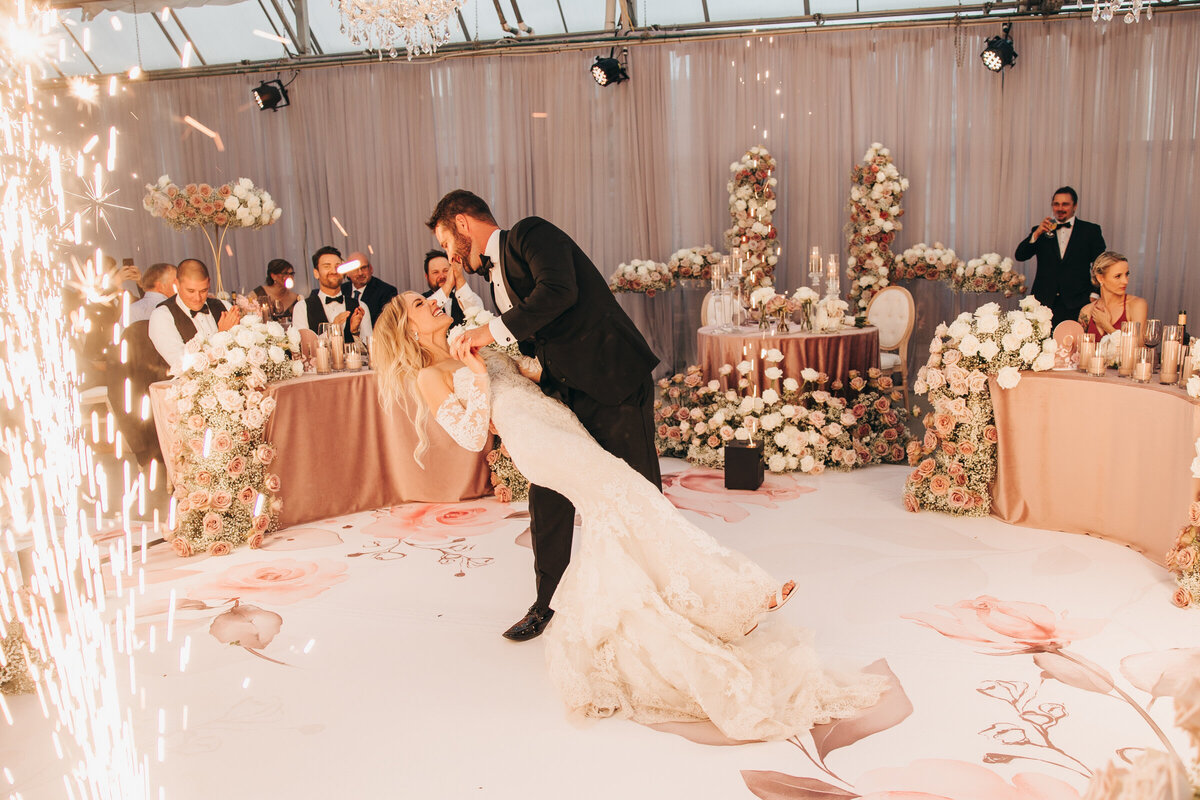 Groom dips bride during first dance and glamorous wedding