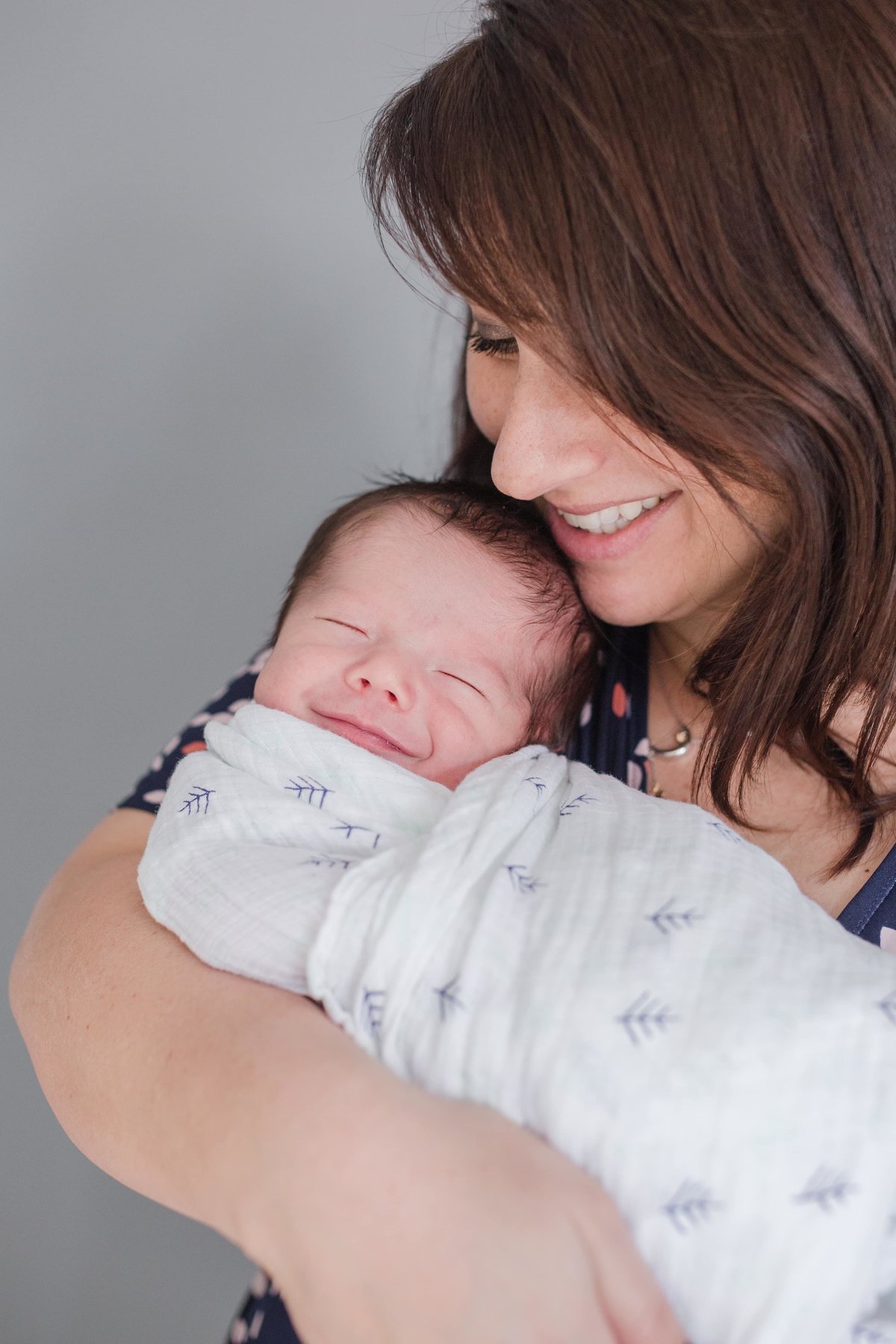 Maira Ochoa Photography - Chicago Newborn smiling to the camera hold by mom