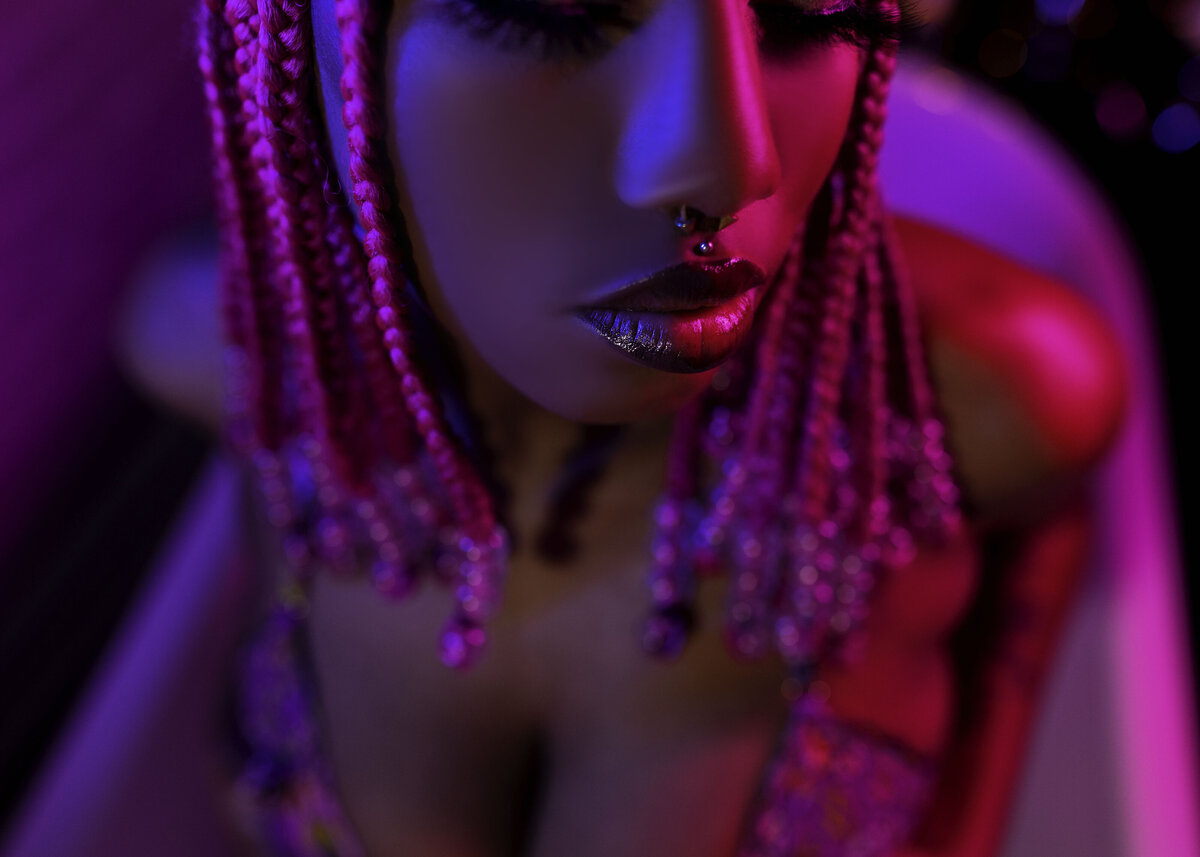 close up black woman laying in clawfoot tub in neon lighting in lingerie boudoir