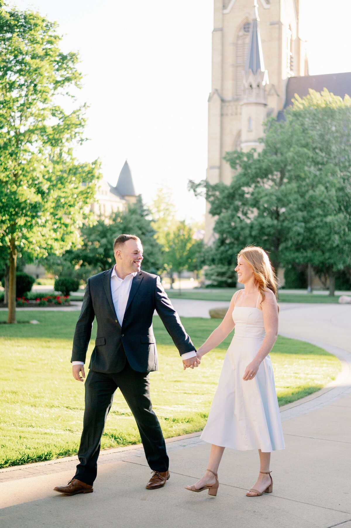 man holding hands and walking with his fiance