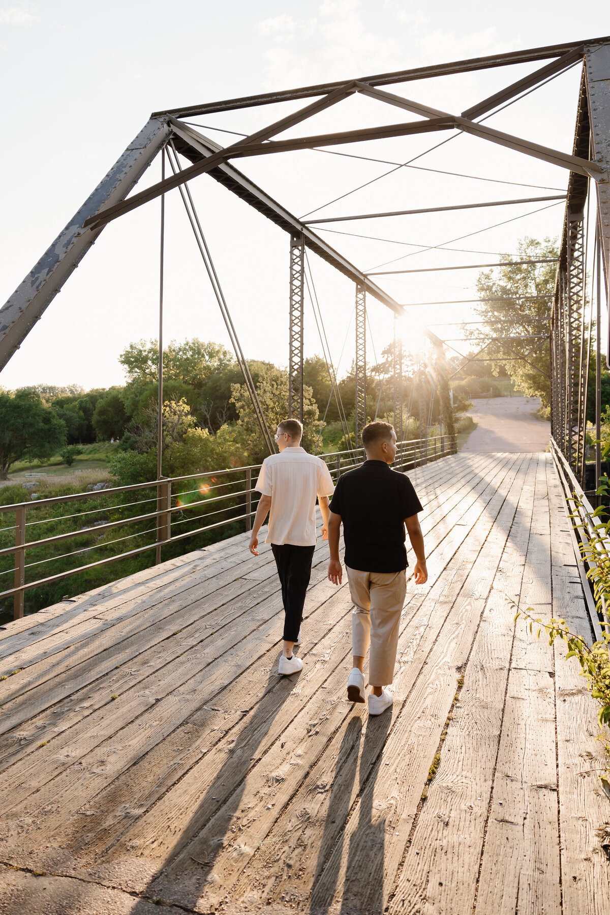 Two people walking along a bridge