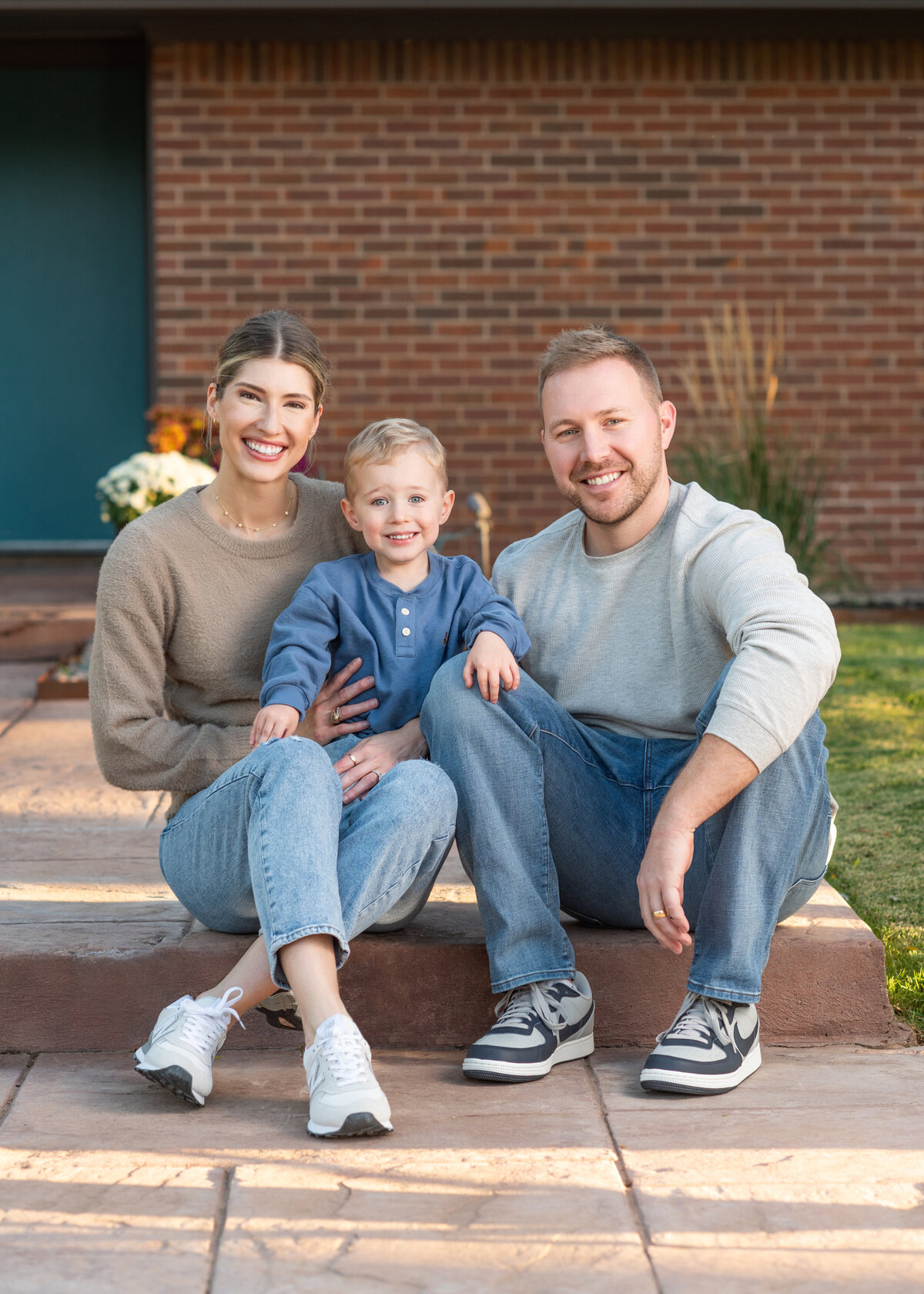 Mom and Dad holding their young son for their fall seasonal family photo