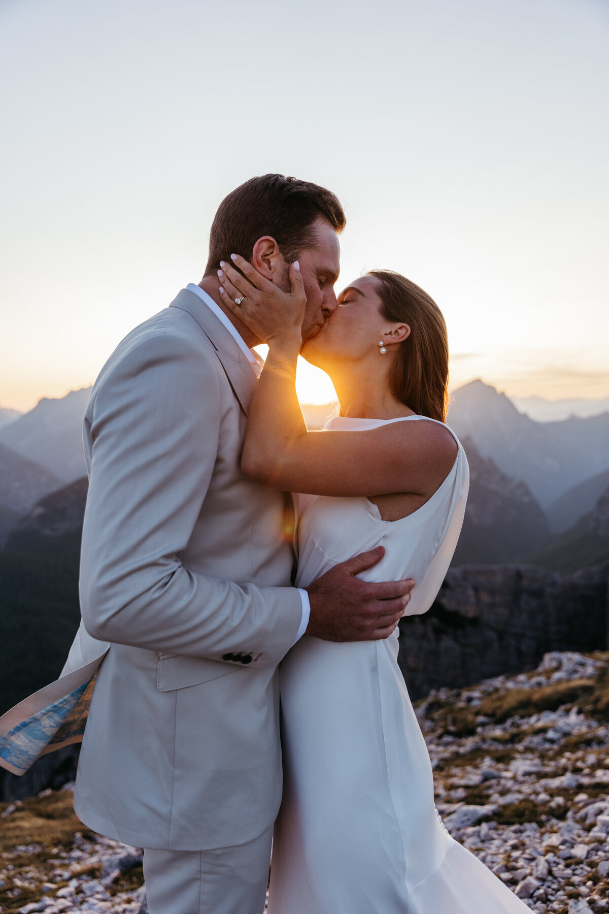 Sweet couple kissing mountain top elopement Tre Cime Dolomites