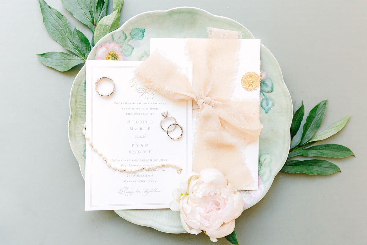 Wedding invitation suite styled with florals on decorative plate