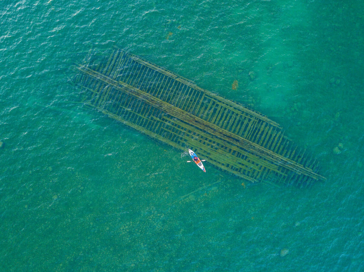 Photographer from Cleveland kayaks over a shipwreck in a lake in Michigan. Photo taken by Sam Young Studios