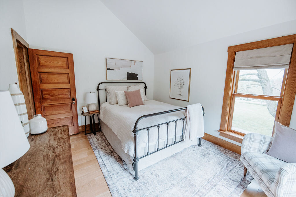 the rose bedroom with Pottery barn neutral striped bedding and West Elm rose pink velvet pillows in the modern farmhouse overnight accommodations at Willowbrook wedding venue