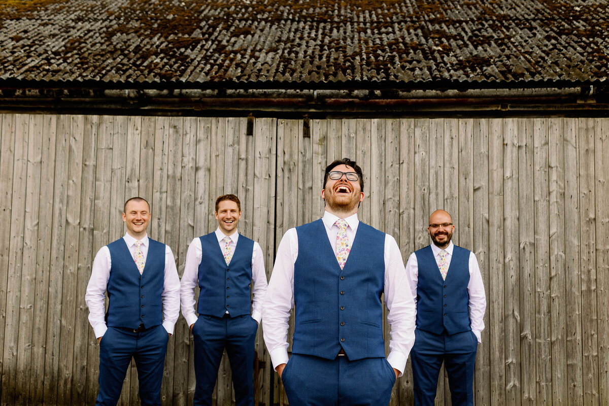Candid groomsmen photo with the groom laughing