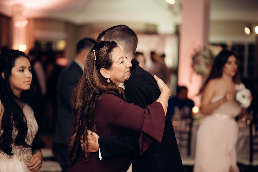 Wedding Photograph Of Groom Hugging a Woman In Maroon Dress Los Angeles