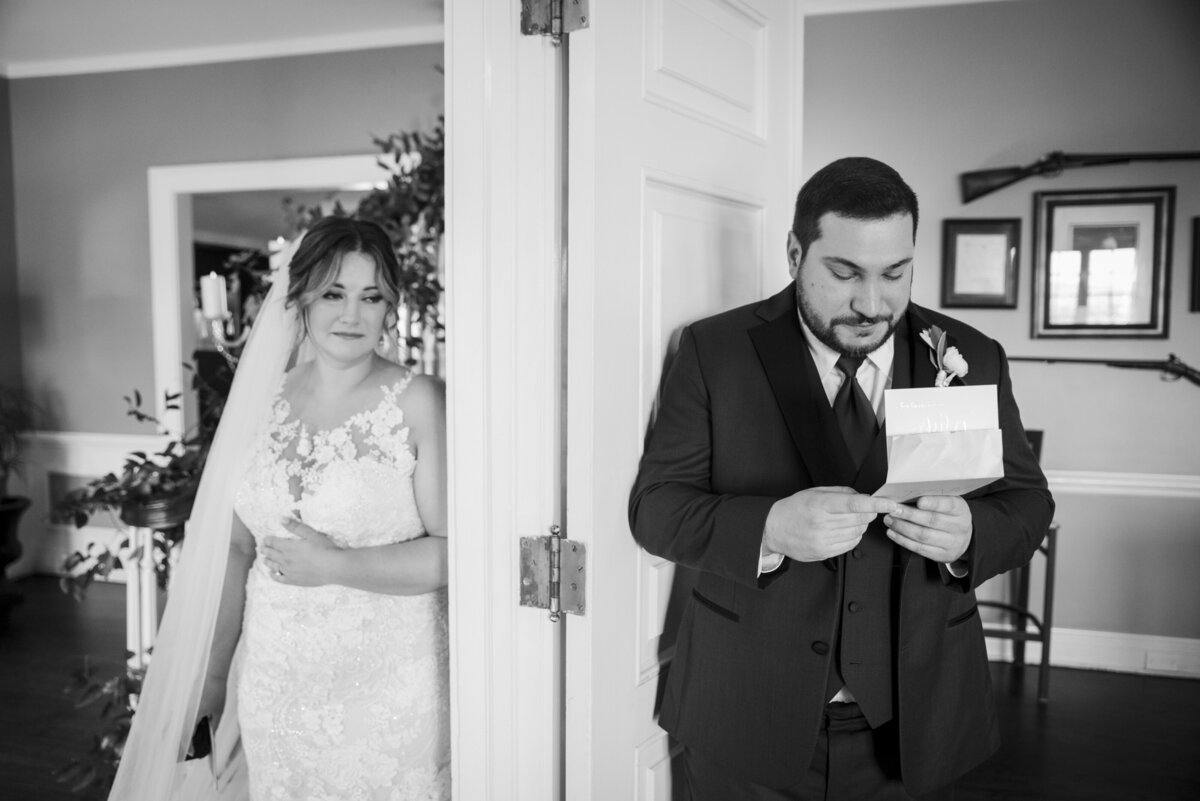 A bride and groom stand on opposite sides of a doorway without seeing each other as they share letters written to one another.