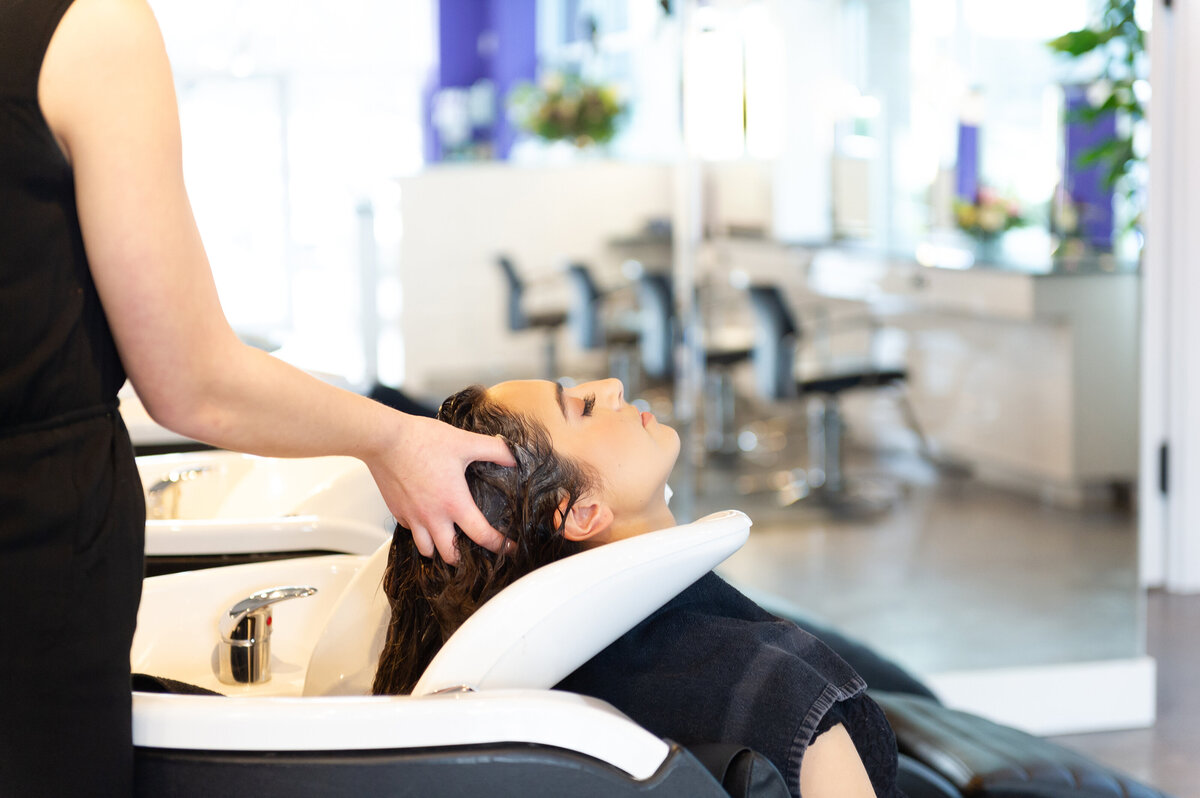 Client receiving luxurious shampoo with eyes closed