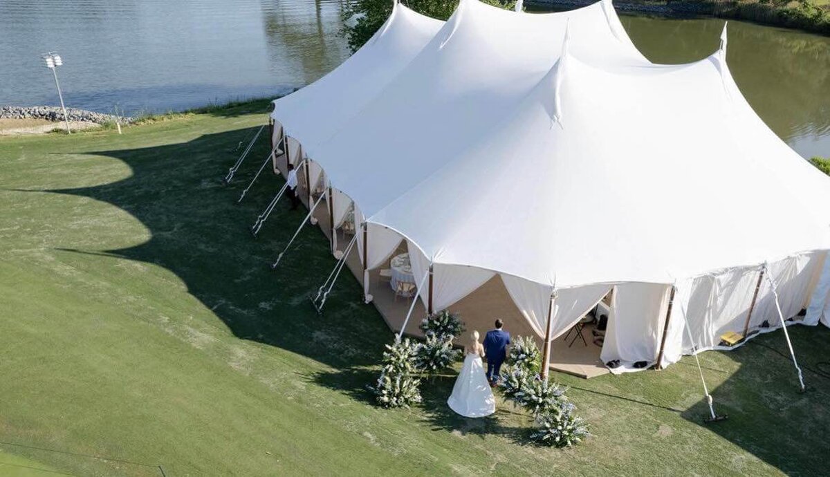 A picturesque wedding tent set on a lush golf course, creating a serene and elegant ambiance for the special occasion.