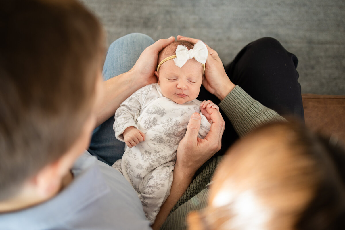 Mom and dad holding baby during newborn photo shoot