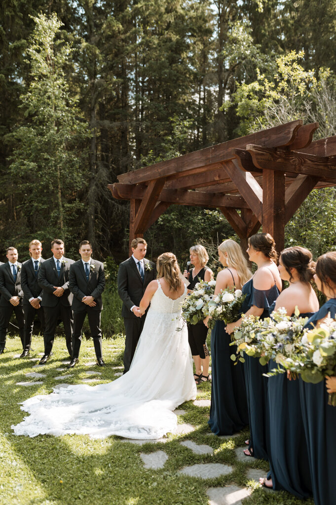 Outdoor summer ceremony at The Valley Weddings, a rustic and majestic wedding venue in Westerose, Alberta, featured on the Brontë Bride Vendor Guide.