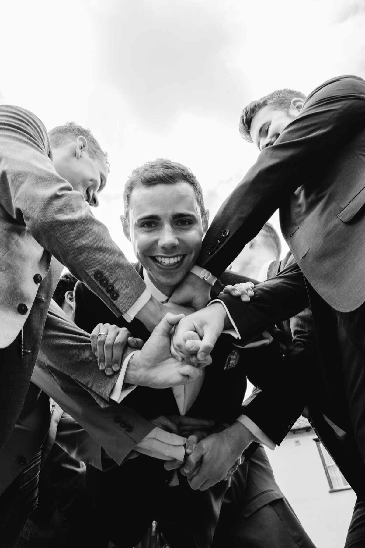 groom being thrown in the air by groomsmen