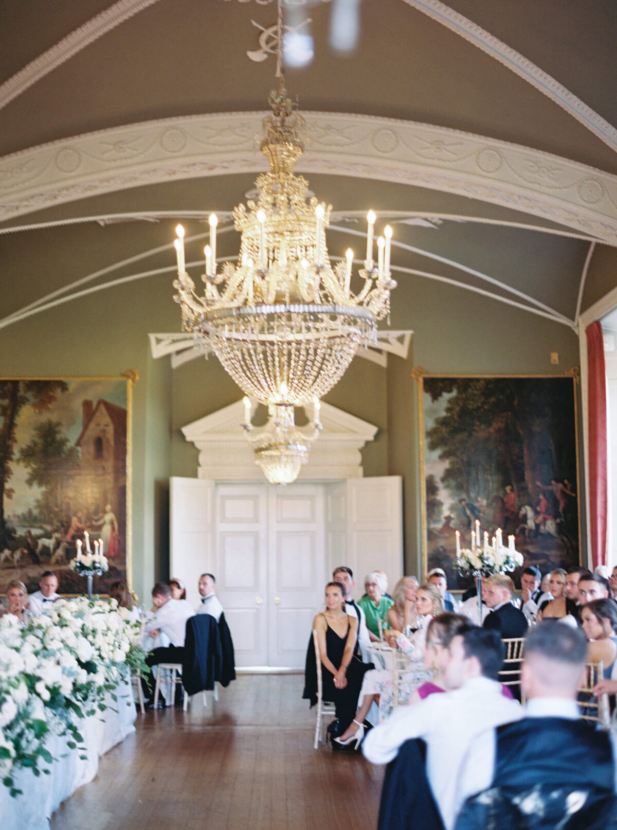 A wedding photo of guests sitting for dinner in the reception hall in Luttrellstown Castle