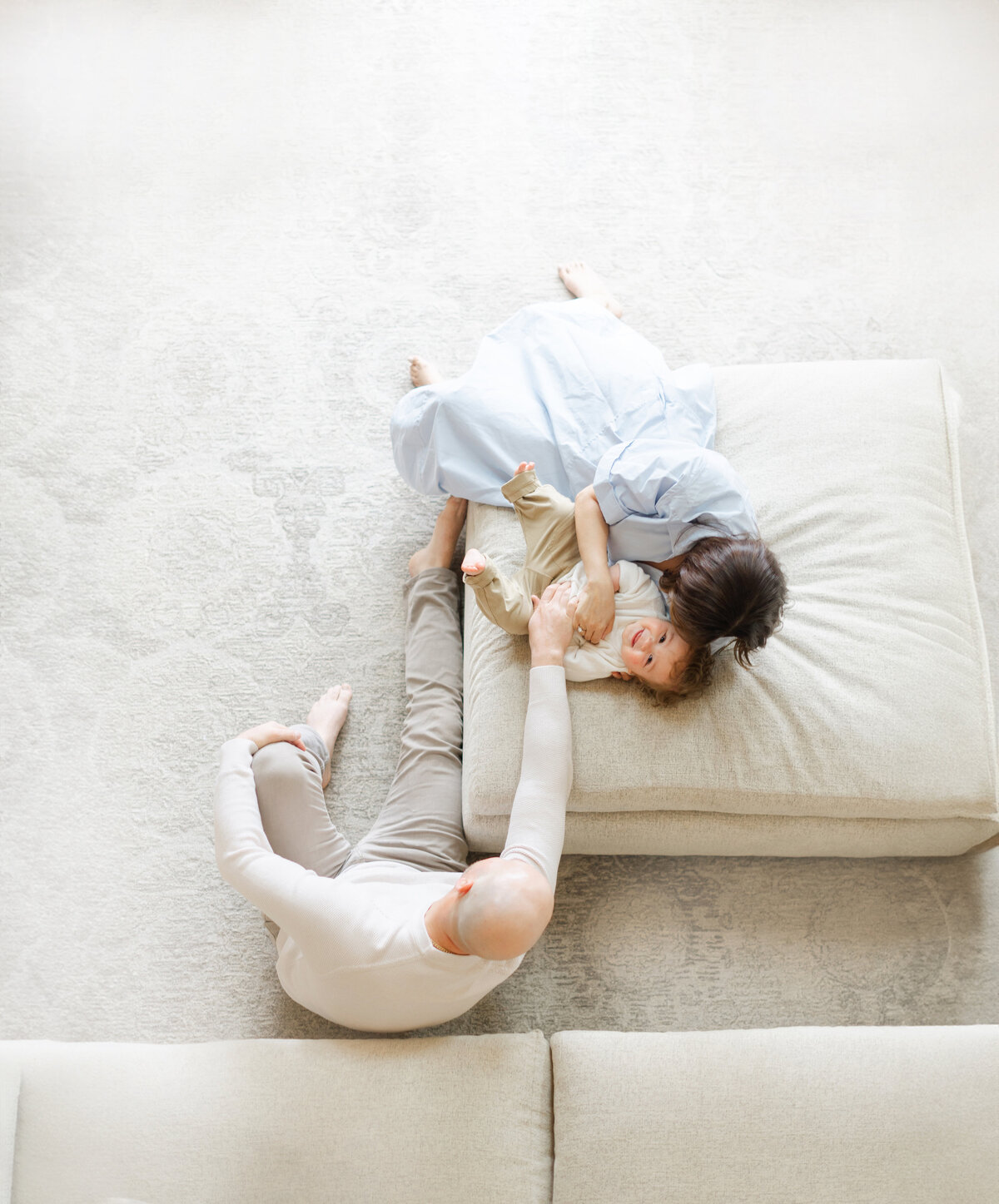 Dad and big sister reach to tickle new baby