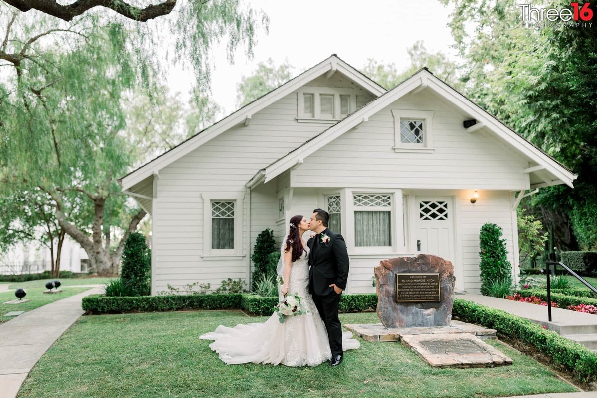 Bride and Groom kiss in front of the Richard Nixon Birth Home