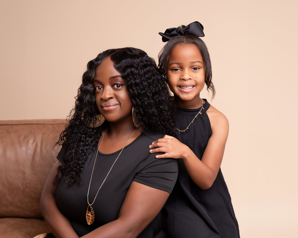 Mother and daughter smile for their portrait in the Adair Photography portrait studio