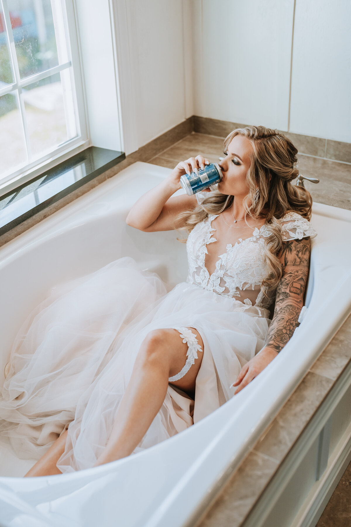 bride in her wedding dress relaxing enjoying a natty ice in the bathtub before ceremony