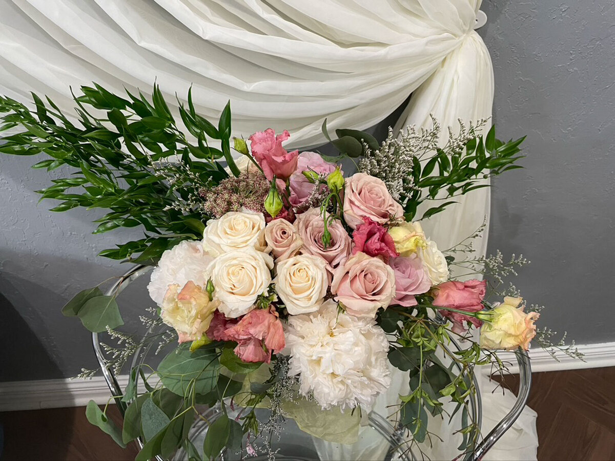 Elegant pastel bouquet with greenery on a chair