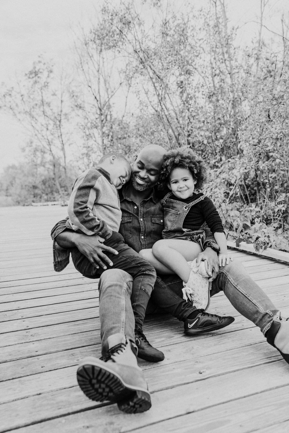 Celebrate family ties with a timeless portrait captured at Roseville's Central Park. Embrace the genuine moments shared between a loving dad and his children in this picturesque outdoor setting