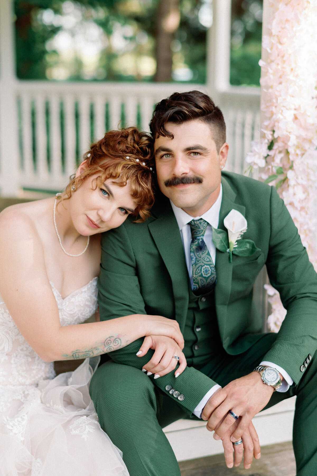 Stunning ginger haired bride embracing groom in green wedding suit, captured by Kaity Body Photography, elegant film inspired wedding photographer in Calgary, Alberta. Featured on the Bronte Bride Vendor Guide.