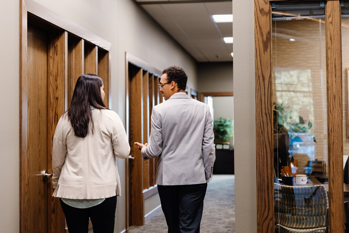 Two people walking together in an office