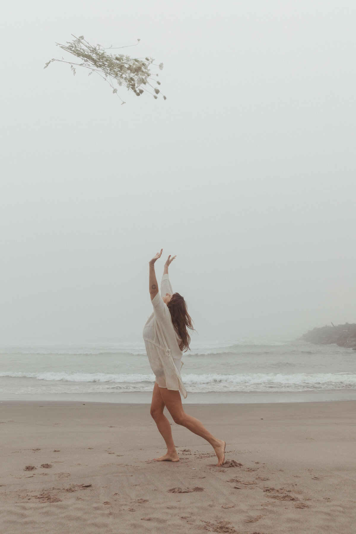 Artisti portrait of woman throwing wildflowers in the air at the Oregon Coast by Karen Pride Photography
