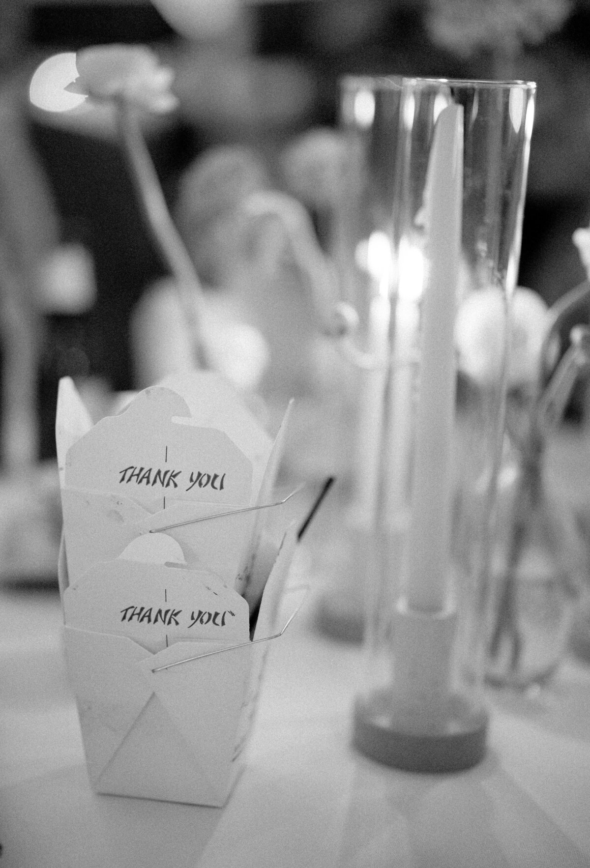 Black and white of takeout boxes and candles on a wedding reception table