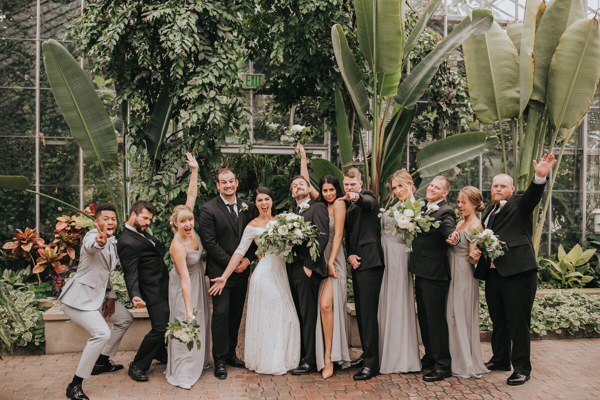 Wedding part celebrating with goofy poses inside conservatory