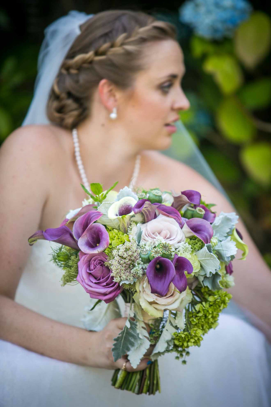 bridal bouquet with purple roses, purple calla lilies, blush roses,and greenery