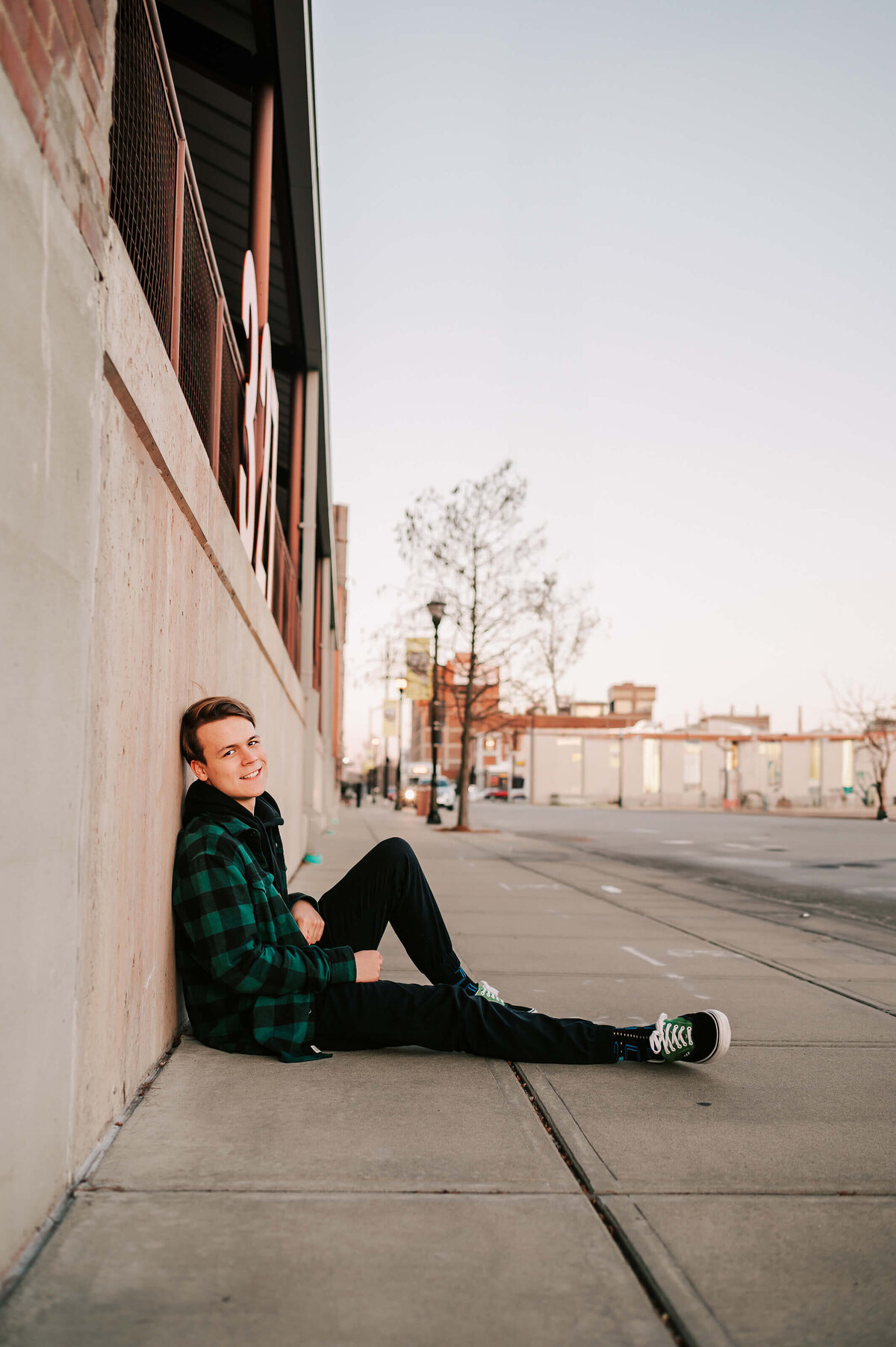 Teenage boy sitting on sidewalk captued by Branson Missouri senior photographer Jessica Kennedy of The XO Photography