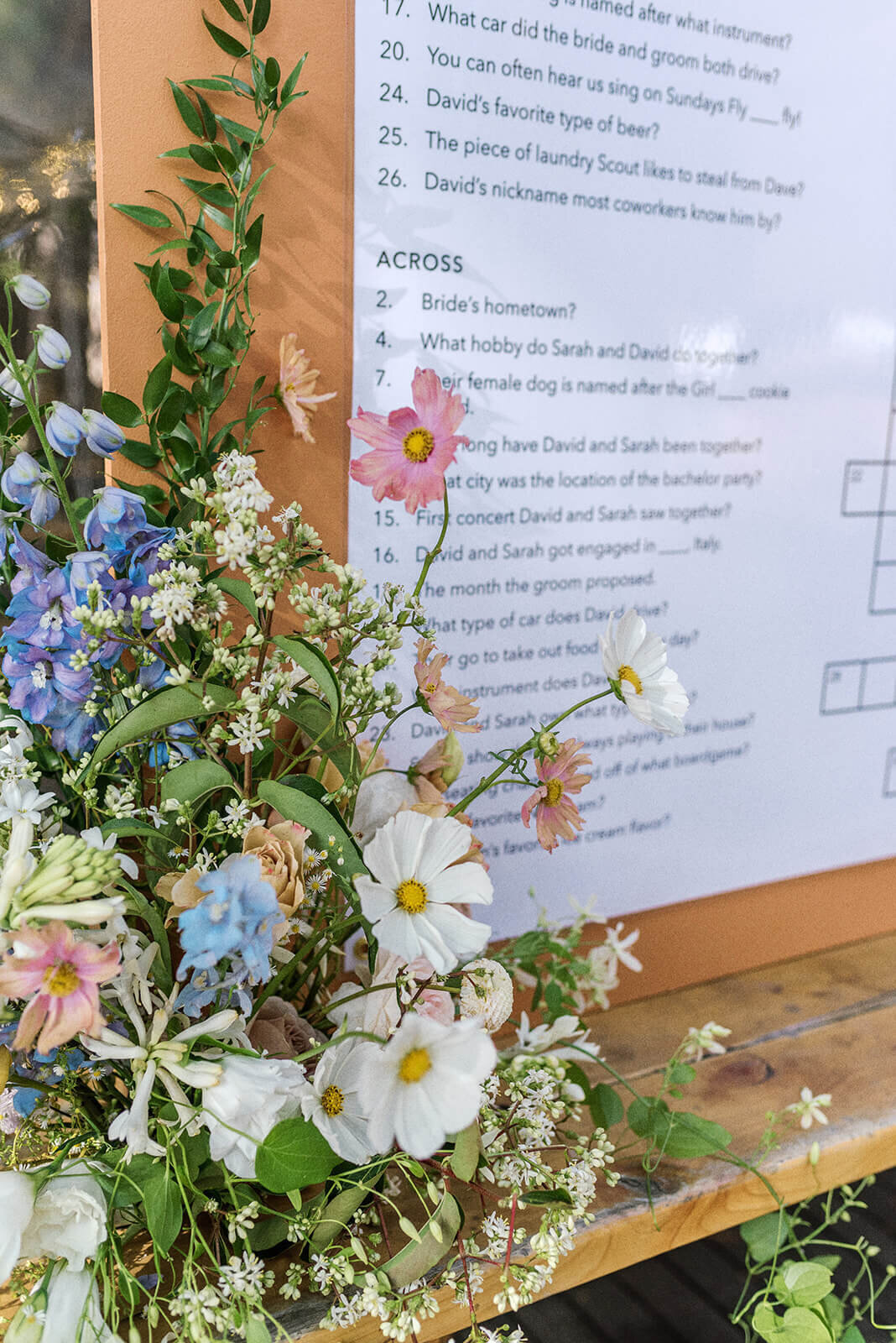 A close up of flowers and a large cross word puzzle used as a seating chart at a wedding.