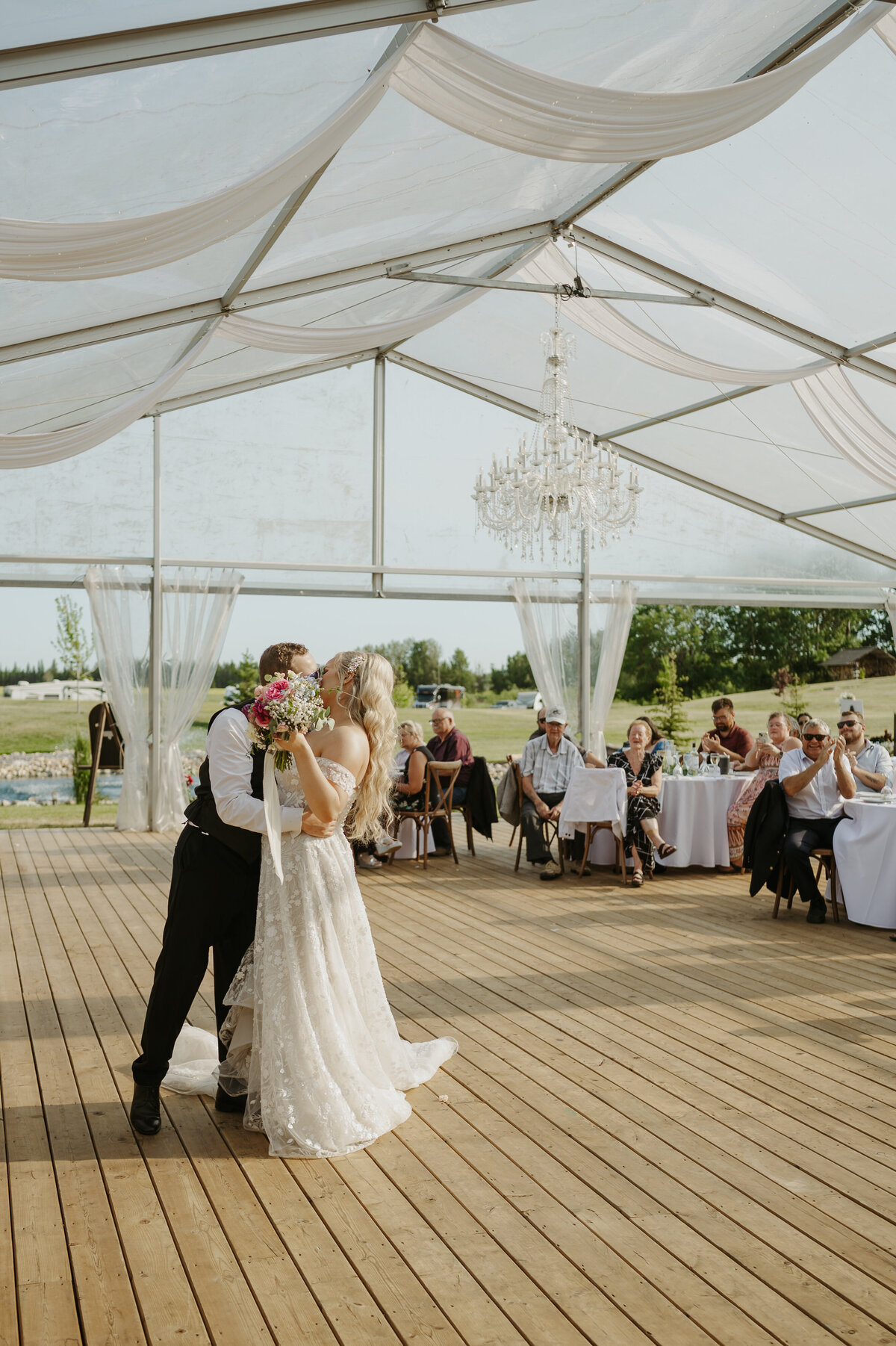 couple kissing in receptiont ent of wedding