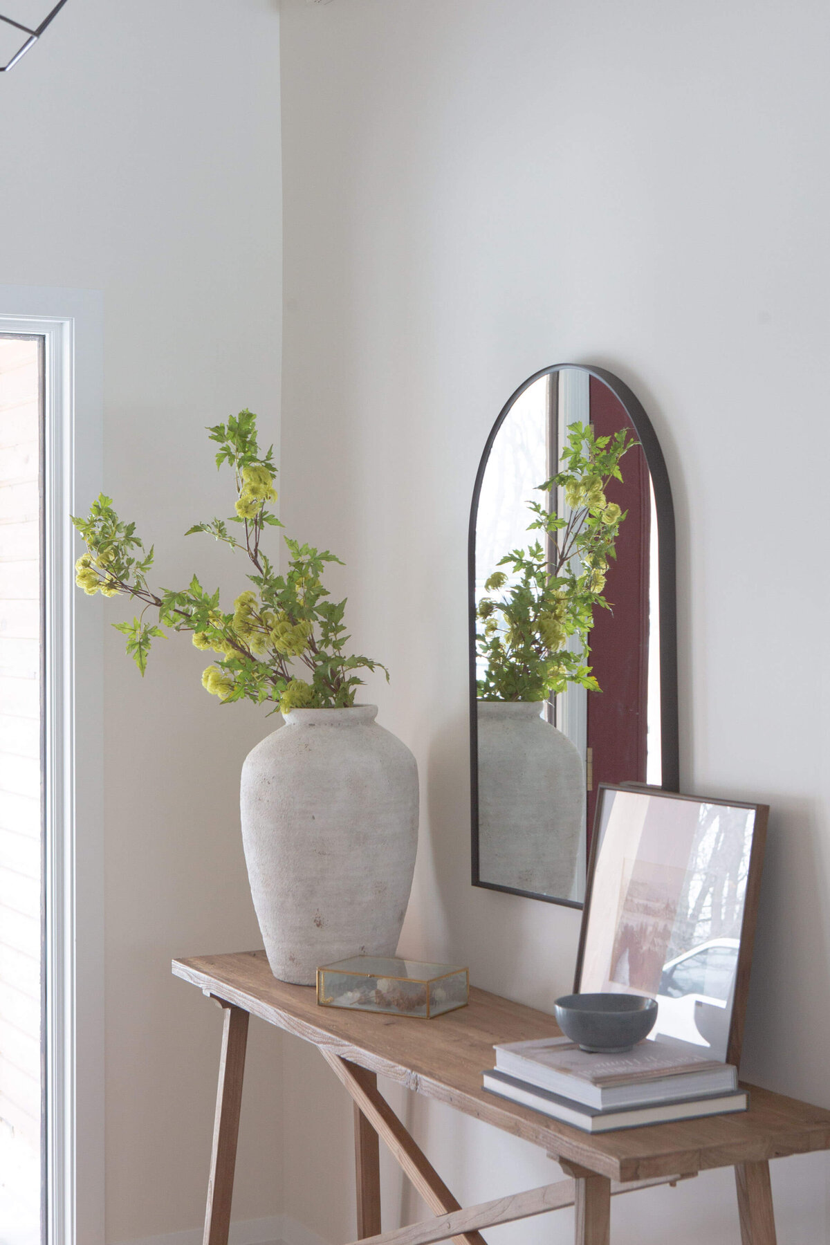 showhome entryway styled with rustic wood console table and arched mirror