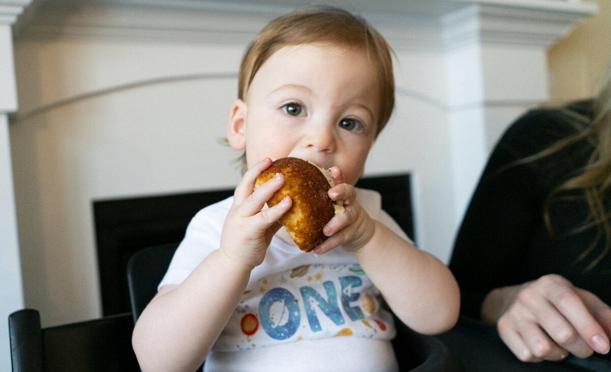 Photo of an infant eating cake at their first birthday party