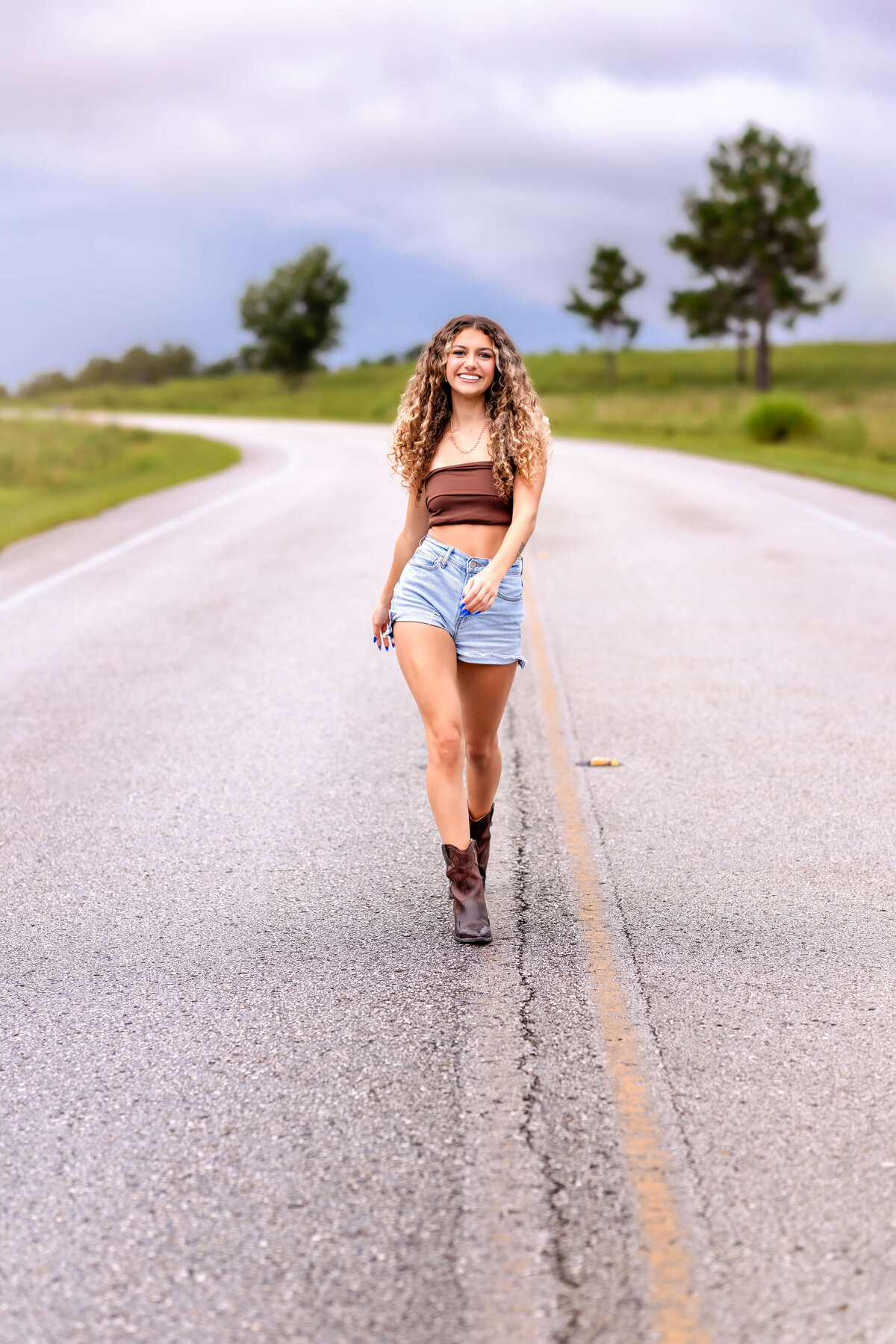 Dreamy Orlando senior photo of a teen girl walking along a windy country road.
