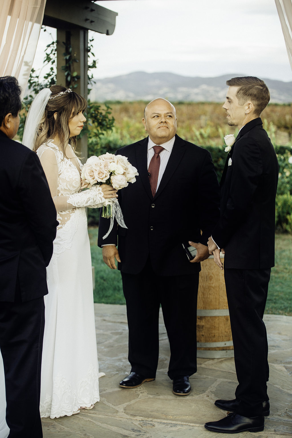 Wedding Photograph Of Two Men in Black Suit And Bride Carrying a Bouquet Los Angeles