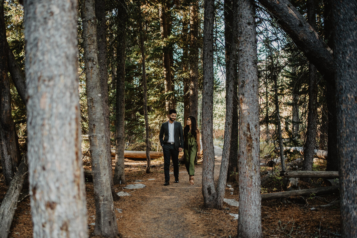 engaged couple walking through a grove of trees in Jackson Hole for their fall engagement session