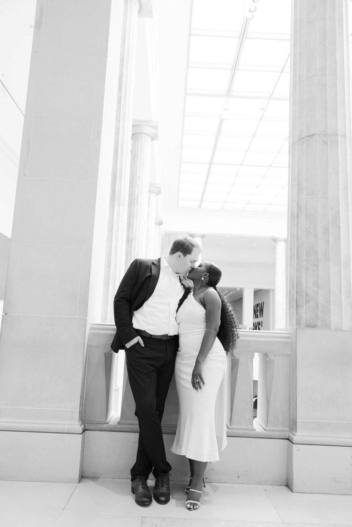 Couple posing for engagement photos outside the Art Institute of Chicago with iconic architecture in the background.