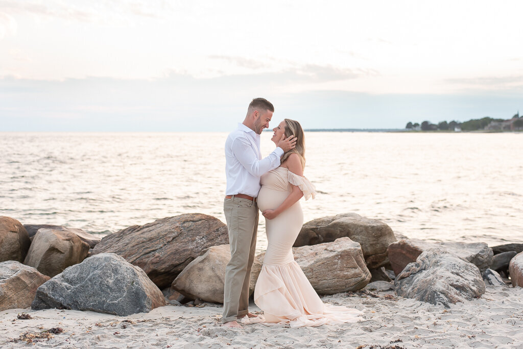 Parents kissing on beach during maternity sunset session |Sharon Leger Photography || Canton, CT || Family & Newborn Photographer
