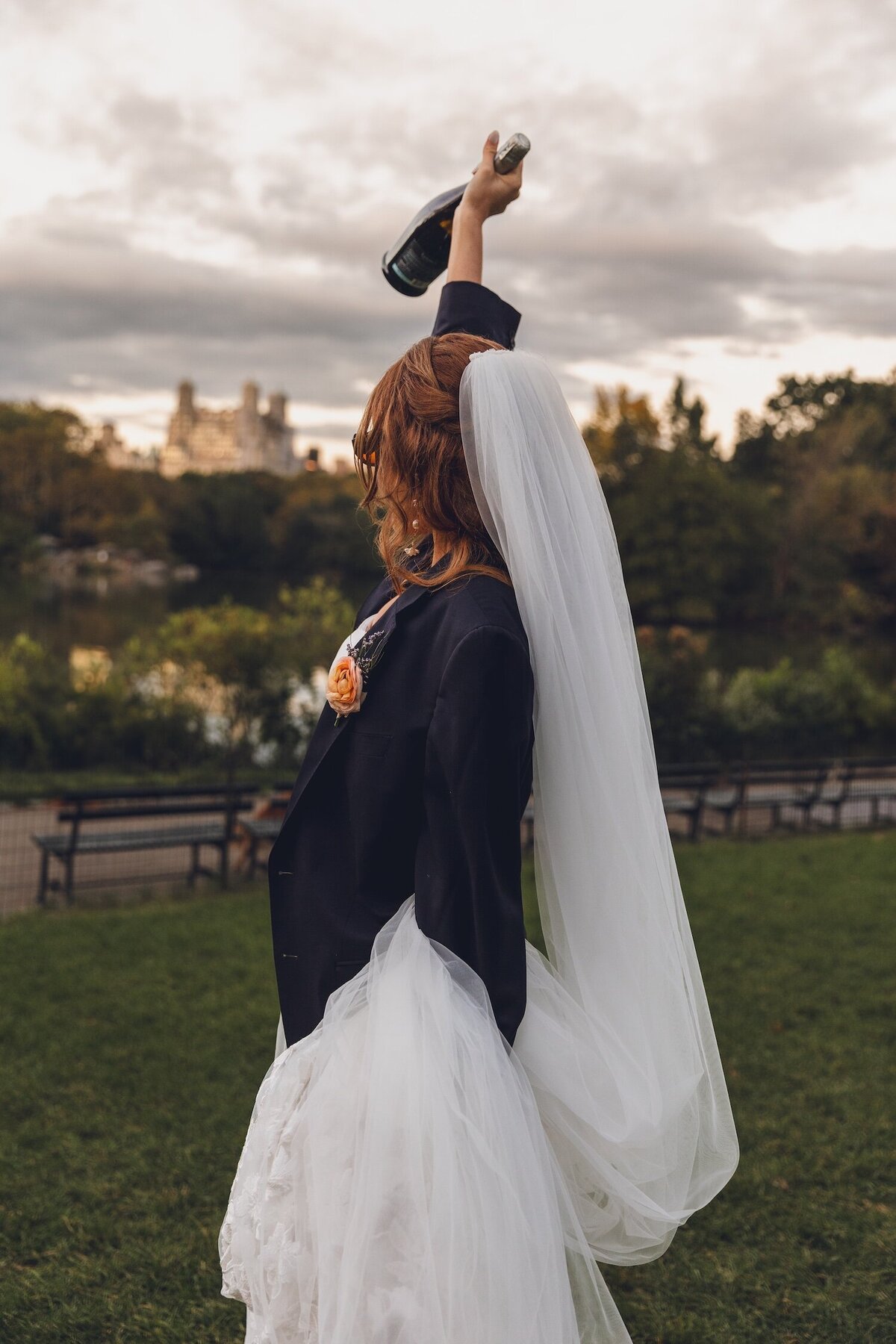 Bride dancing with champagne bottle in raised arm