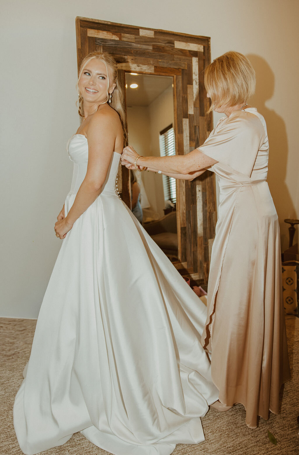 Bride's dress being fastened before the ceremony