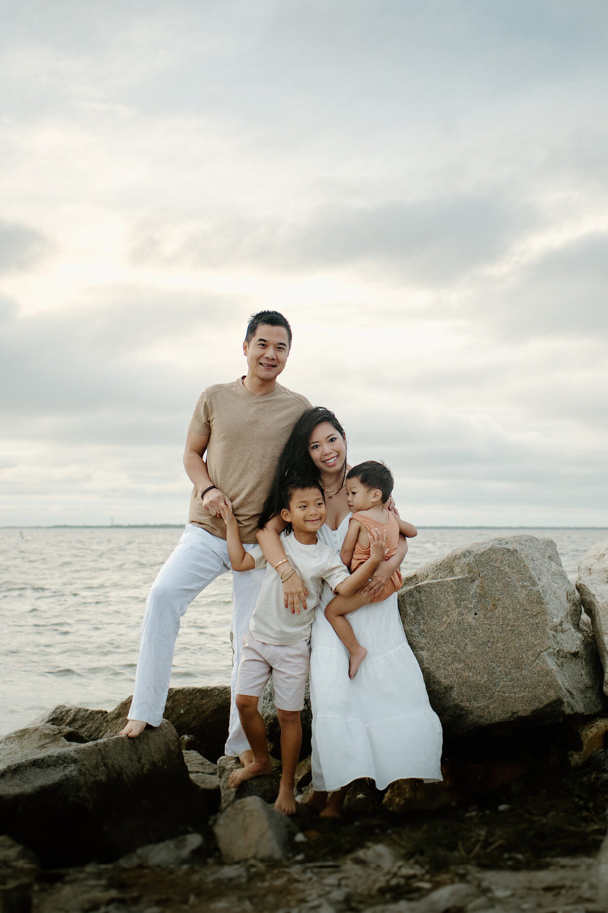 Family photography family photo woman holding children with man by ocean in Tampa Bay, Florida Nadine B Photography