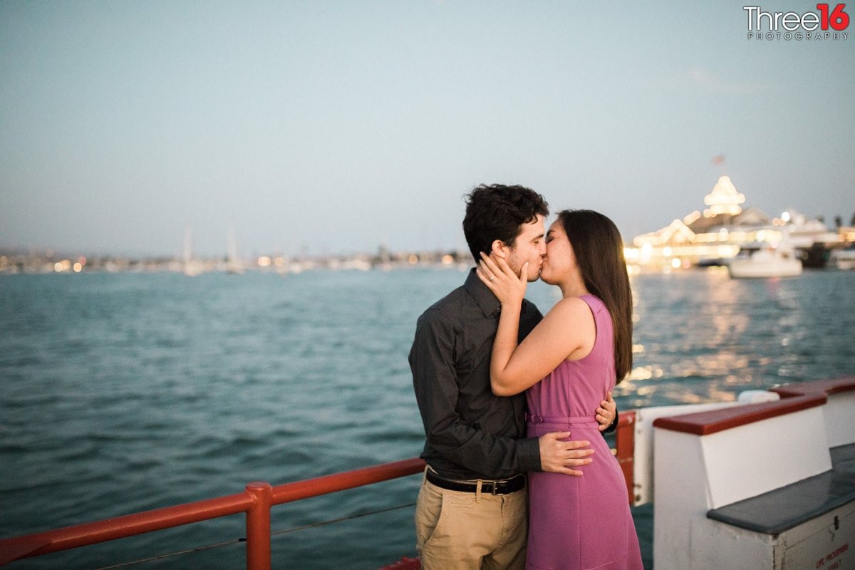 Engaged couple share a romantic kiss while on the Balboa Island Ferry
