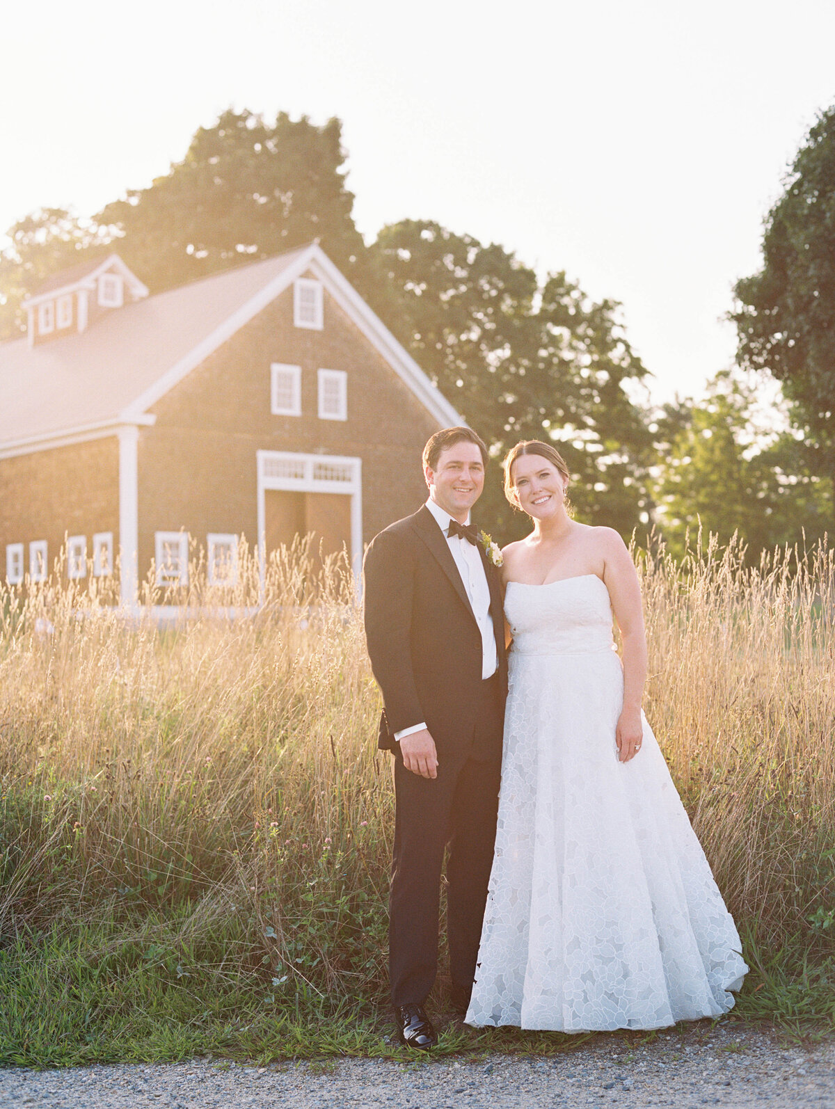 bride and groom with sunset and barn