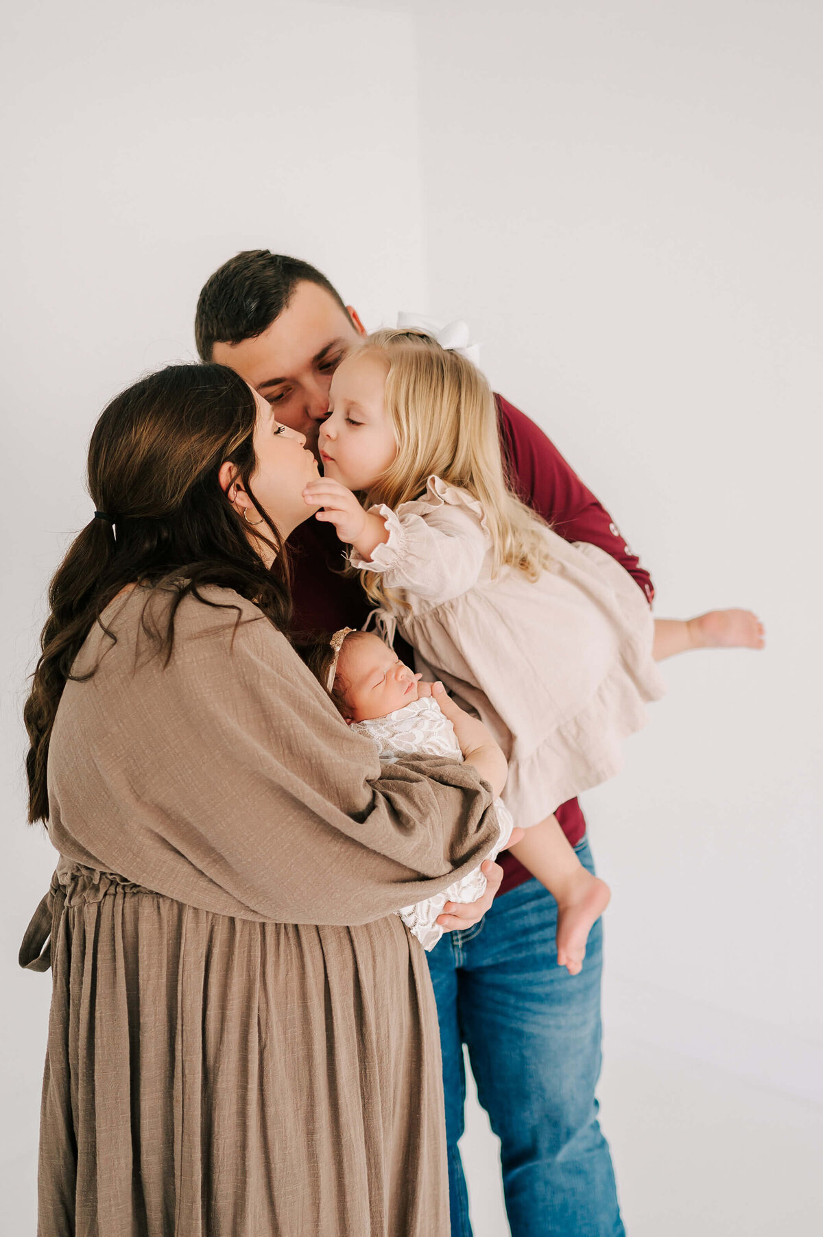 Springfield Mo newborn photographer Jessica Kennedy of The Xo Photography captures toddler kissing mom holding a newborn