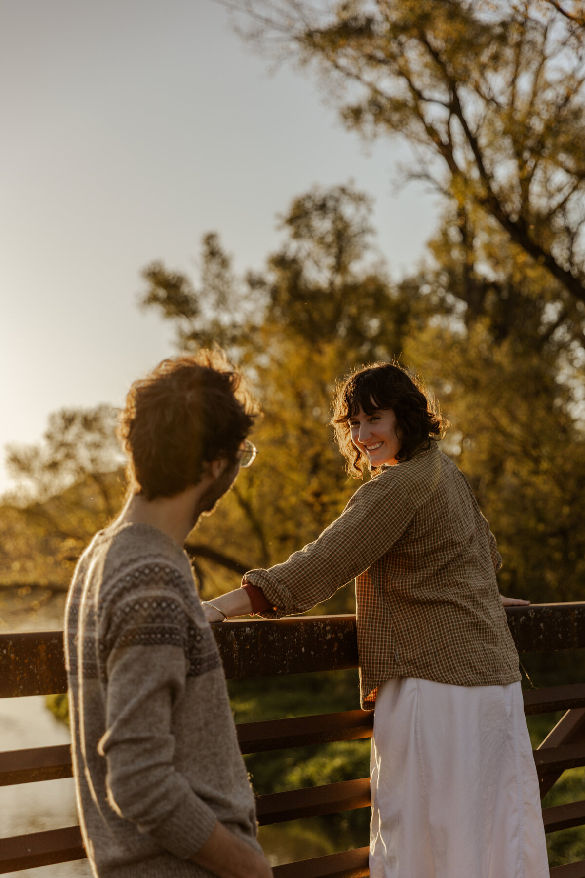 Engagement Photos at golden hour where girl is looking at boy while laughing 
