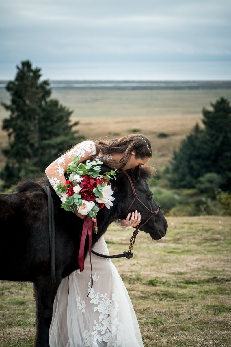 A tender moment as the bride shares a sweet kiss with her beloved pony at the North Coast Hitching Post in Loleta. This enchanting shot captures the rustic elegance and personal touches of her wedding day, surrounded by the natural beauty of Humboldt County.